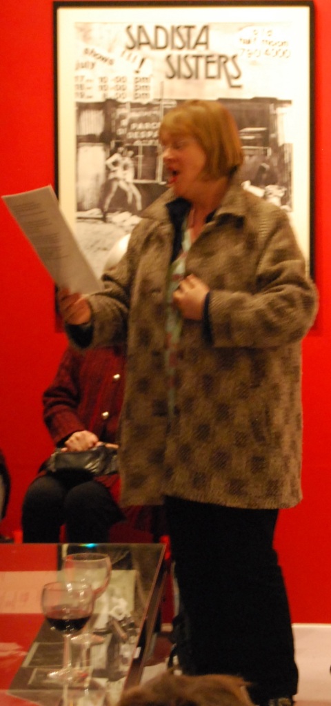 Lizzy is pictured singing emphatically, reading the words from a sheet of paper